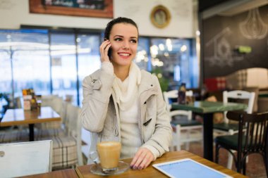 Kafede dijital tablet kullanarak çekici genç kadın