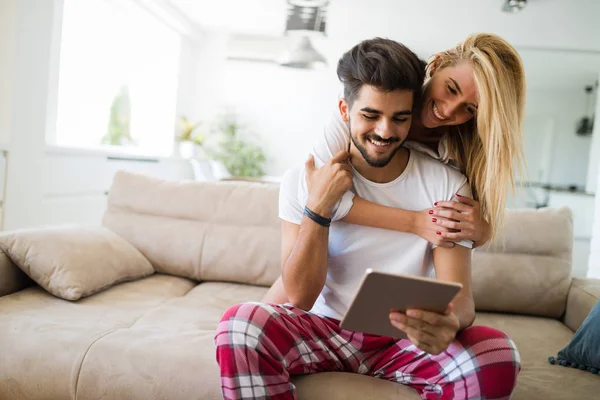 幸福夫妻穿着睡衣在家使用平板电脑的爱 — 图库照片