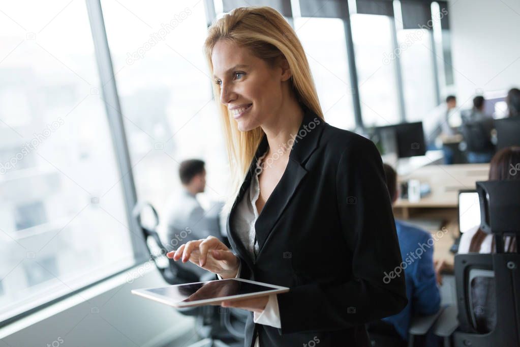 Attractive businesswoman using digital tablet in modern office