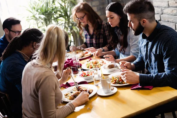 Grupo de jovens colegas de trabalho socializando em restaurante — Fotografia de Stock