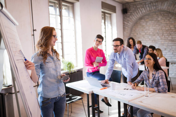 Portrait of young attractive architect doing presentation to her coworkers