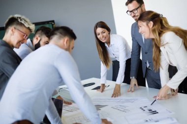 Takım inşaat planları üzerinde birlikte çalışan mimarlar