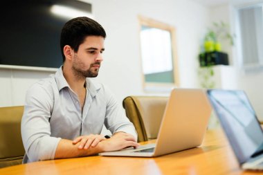 Modern ofis içinde bilgisayar üzerinde çalışan işadamı resmini