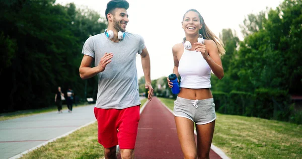 Athletic young cute couple jogging together outdoors