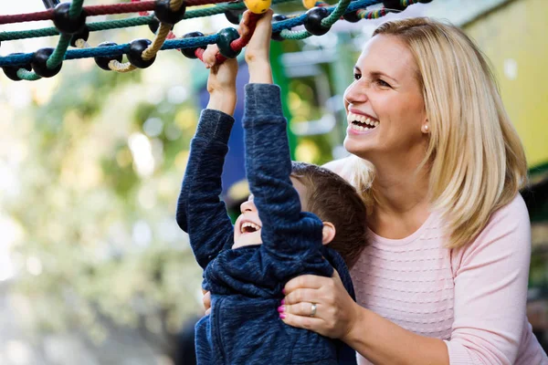 Bir anne ve oğlu parkta oynarken eğleniyor