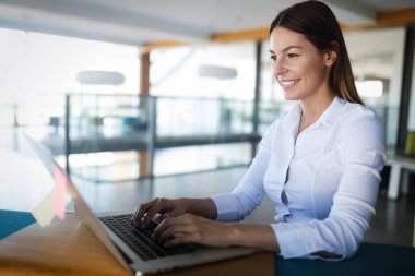 Ofiste dizüstü bilgisayarla çalışan çekici genç bir kadın mimar.