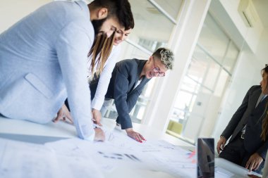 Bir grup mimar ve iş adamı birlikte çalışıyor ve beyin fırtınası yapıyorlar.