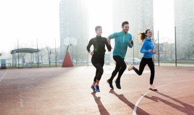 Mutlu arkadaşlar spor yaparken dışarıda aktif ve sağlıklı bir yaşam sürerler.