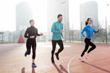 Mutlu arkadaşlar spor yaparken dışarıda aktif ve sağlıklı bir yaşam sürerler.