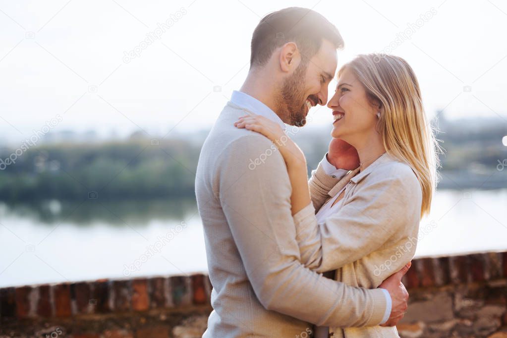 Happy couple in love hugging and smiling outdoor