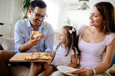 Mutlu aile birlikte evde pizza paylaşımı gülümseyen