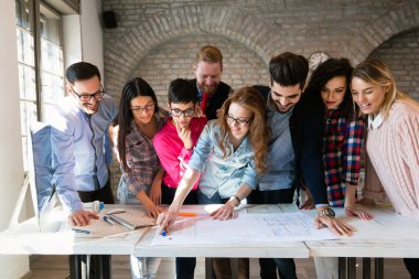 Bir grup mimar ve iş adamı birlikte çalışıyor ve beyin fırtınası yapıyorlar.