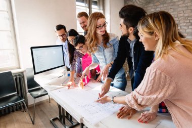 Bir grup mimar ve iş adamı birlikte çalışıyor ve beyin fırtınası yapıyorlar.