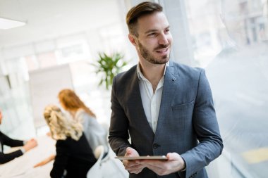 Mutlu işadamı tablet kullanarak modern ofis takım elbise giymiş