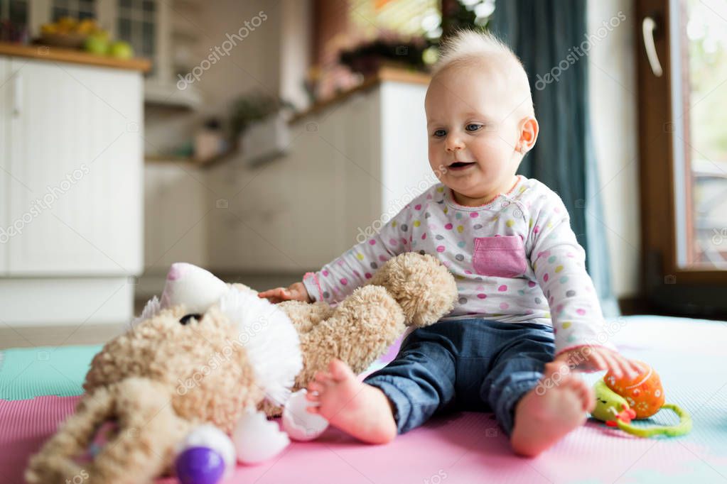 Baby toddler girl playing color toys at home or nursery