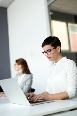 Genç güzel çalışan bilgisayarda çalışma gün boyunca ofiste çalışıyor.