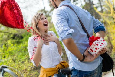Adam ayakta ve doğum günü hediyesi olarak beyaz sürpriz hediye kutusu arkasından tutarak
