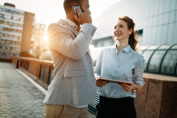Söz ve açık gülümseyen genç iş arkadaşları