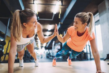 İtme yapıyor iki sportif kız spor salonunda birlikte ups