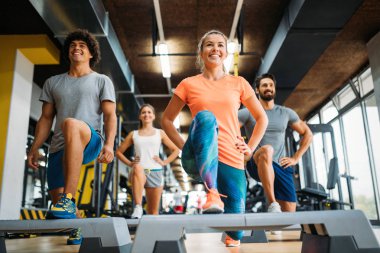 Bir grup genç insan birlikte spor salonunda yapıyor