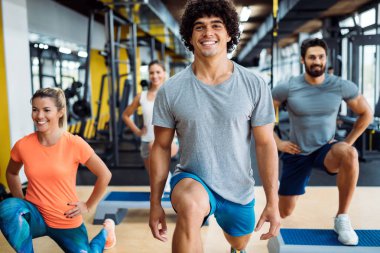 Bir grup genç insan birlikte spor salonunda yapıyor