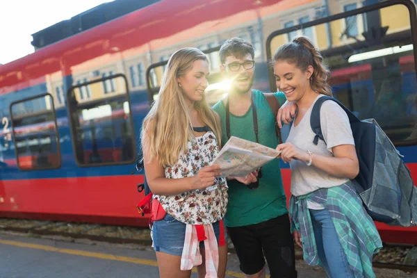 Young group of travelling tourists at train station