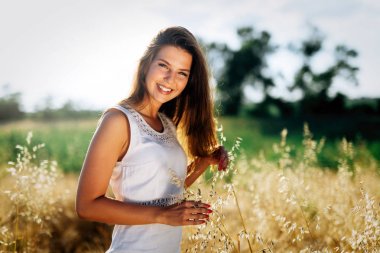 Genç, güzel, mutlu bir kadın doğada vakit geçiriyor.