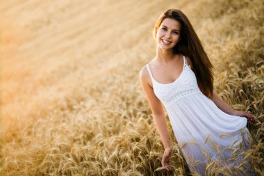 Genç, güzel, mutlu bir kadın doğada vakit geçiriyor.