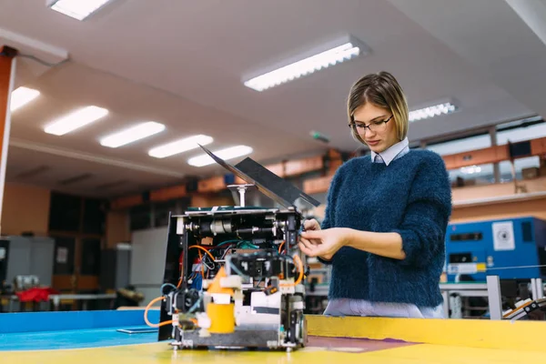 Young attractive student of robotics working on project