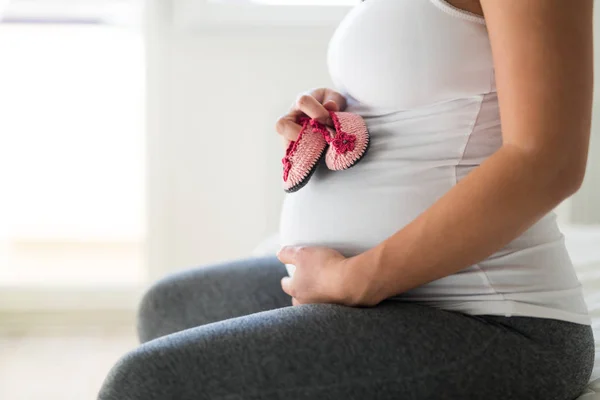 Pregnant Woman Holding Baby Girl Shoes Her Belly — Stock Photo, Image