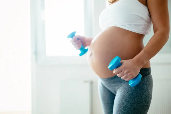 スポーティなフィットネス妊娠中の女性 自宅で演習を行う — ストック写真