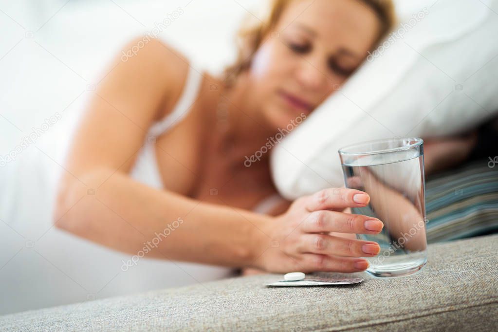Picture of pregnant woman taking medication pills at home