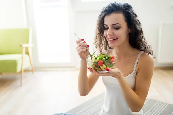 Fitness young woman eating healthy food after workout