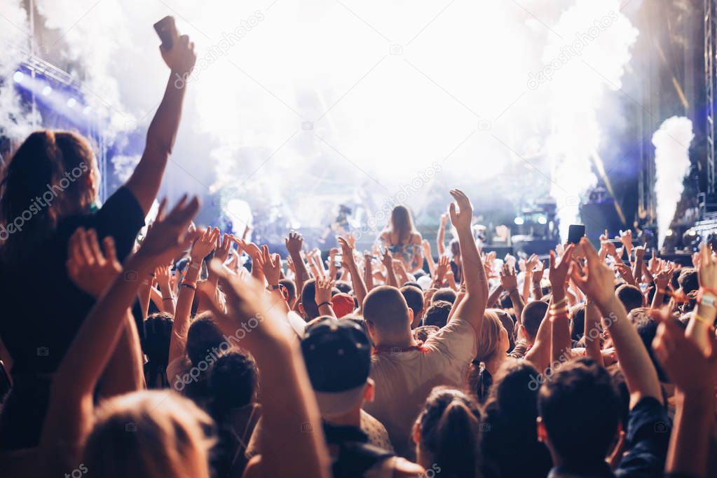 Portrait of happy crowd enjoying and dancing at music festival