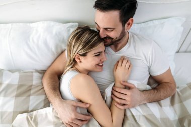 Yatak odasında genç çekici sevgi dolu çift portresi