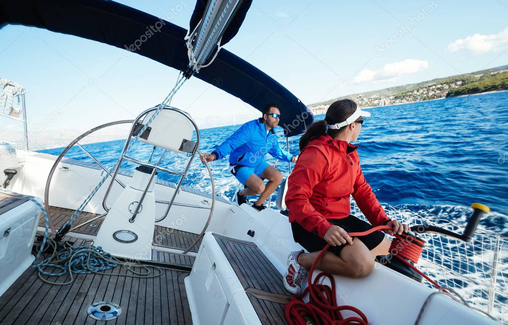 Attractive strong woman sailing with her sail boat