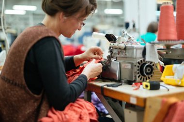 Bir dikiş makinesi tekstil sektöründe çalışan kadın