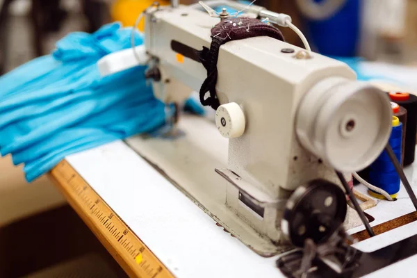 Industrial sewing machine with textile on desk