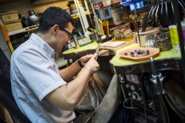 Birçok araç ile tezgah üzerinde çalışan kuyumcu