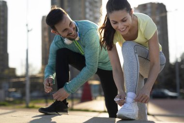 Atletik şirin çift birlikte açık havada koşu ve gülümseyen