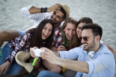 Genç arkadaşlar sahilde bir parti grup portresi