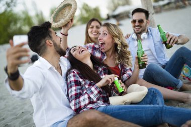 Genç arkadaşlar sahilde bir parti grup portresi