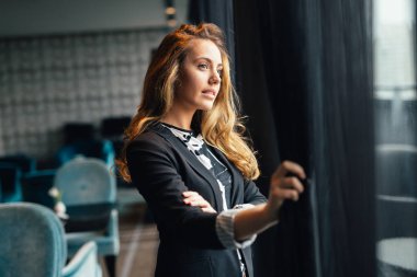 Gökdelen penceresinden bakarak dalgın güzel iş kadını