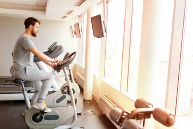 Sportif erkek spor salonunda bisiklet üzerinde egzersiz