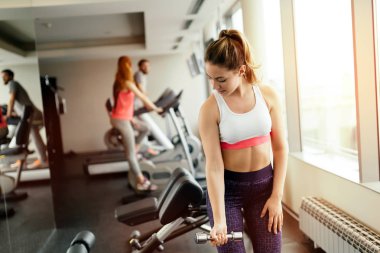 Güzel kadın spor salonunda ağırlık kaldırma tarafından eğitim