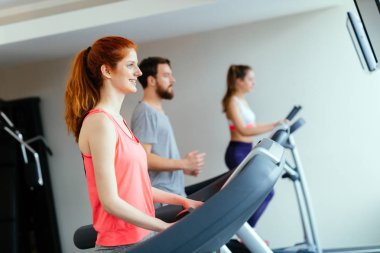 İnsanlar traning kardiyo egzersiz parçası olarak çeşitli makinelerde salonunda