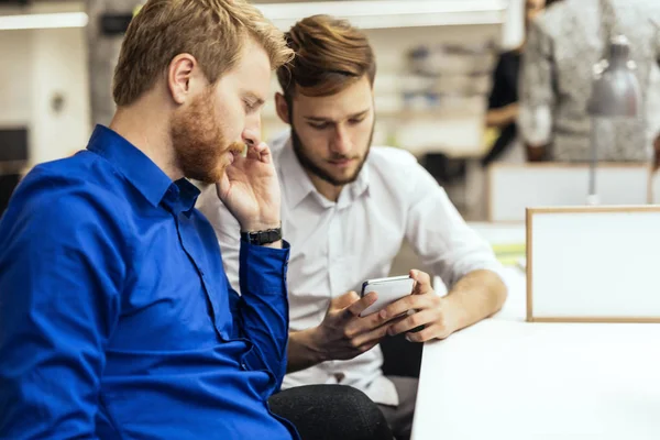 Empresários Bonitos Usando Telefones Chamando Parceiros Enquanto Sentados Mesa Escritório — Fotografia de Stock