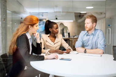 Elinizdeki teknoloji ile masa başında oturan iş arkadaşları
