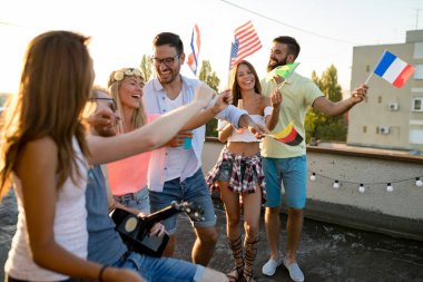 Bir grup ülke bayrakları tutarak ve çatı katında eğleniyor insan