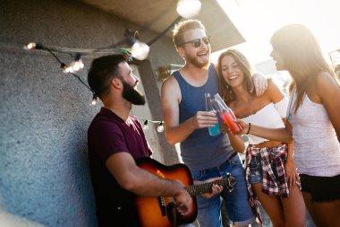 Bir grup arkadaş çatıdaki partide eğleniyor..